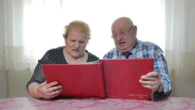 六十年在一起。这对老夫妇看着相册