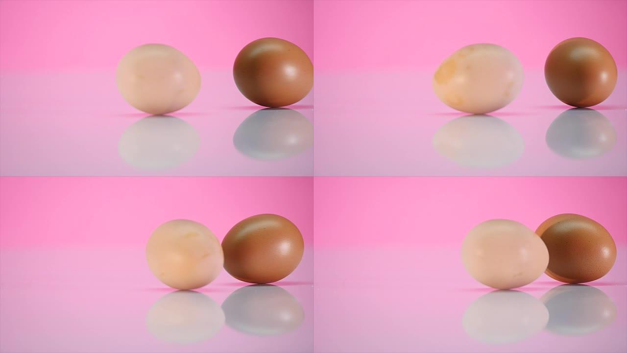 两个鸡蛋在粉红色背景的桌子上旋转
