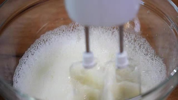 混合甜奶油时加糖。用电机搅拌器在碗中混合白鸡蛋奶油。