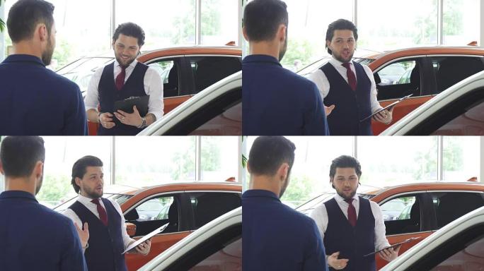 英俊的男汽车经销商与他的男顾客交谈