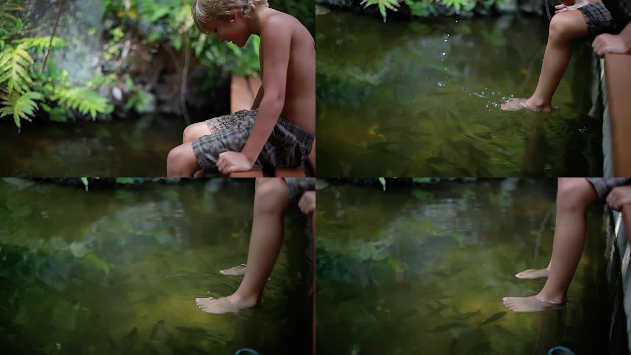可爱的男孩在丛林中的天然池塘里有一个鱼水疗中心。1920x1080