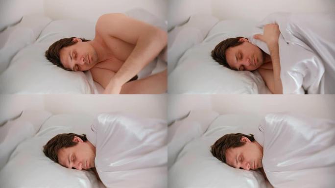 一个人睡在床上，盖着毯子。侧视图。