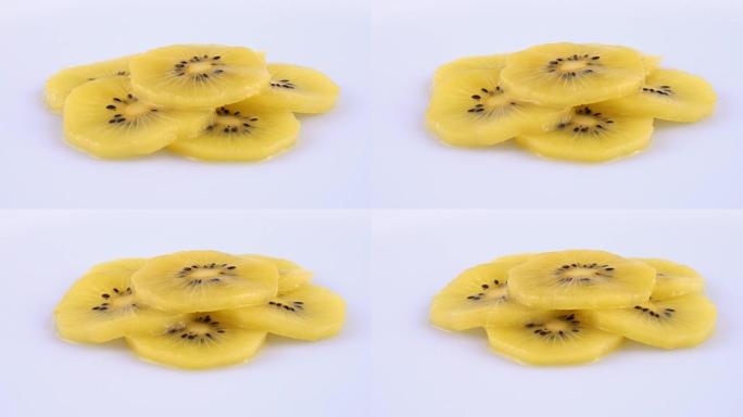 在白色背景上旋转的新鲜多汁的金色猕猴桃 (黄色猕猴桃) 切片。孤立。特写宏观。