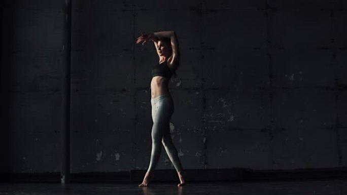 练习瑜伽的女孩。运动员在训练前做伸展运动。穿着运动服装的年轻女子
