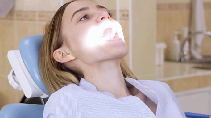 坐在牙医椅上的女孩自己调节光线