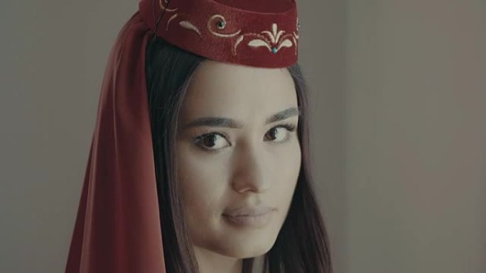 微笑的美丽穆斯林女孩的肖像。传统红色鞑靼服装