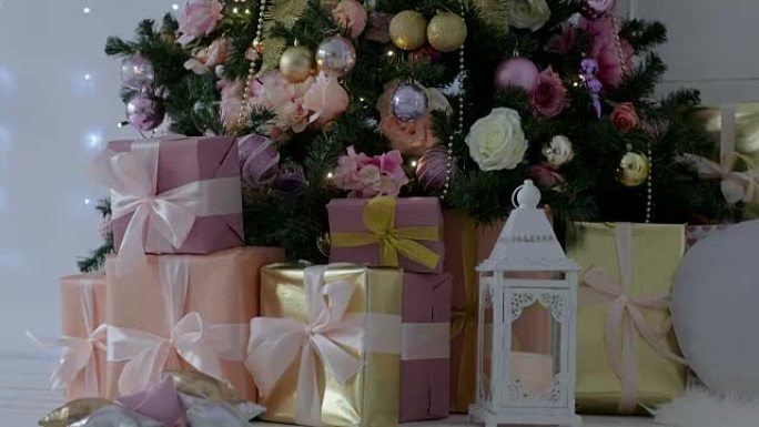 Christmas presents stand under the tree. pink and 