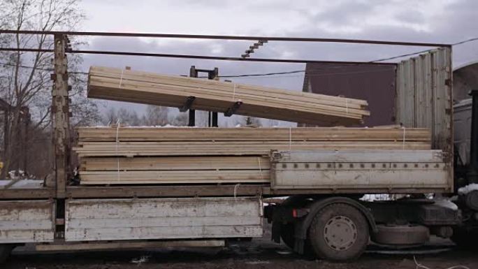 叉车在木工设施上传带有木块堆叠的重型卡车