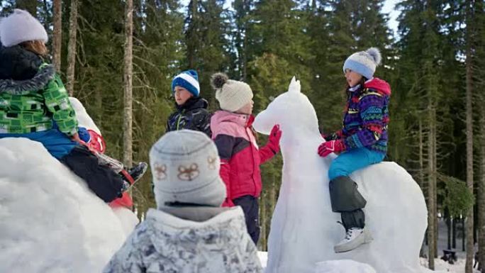 SLO MO的孩子们在白雪皑皑的操场上玩得开心，坐在他们用雪制成的动物上