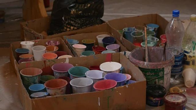 彩色塑料罐，带油漆。艺术家工作场所背景。旧脏油漆背景。彩色艺术家调色板。柔和的色调。创意，视觉艺术概