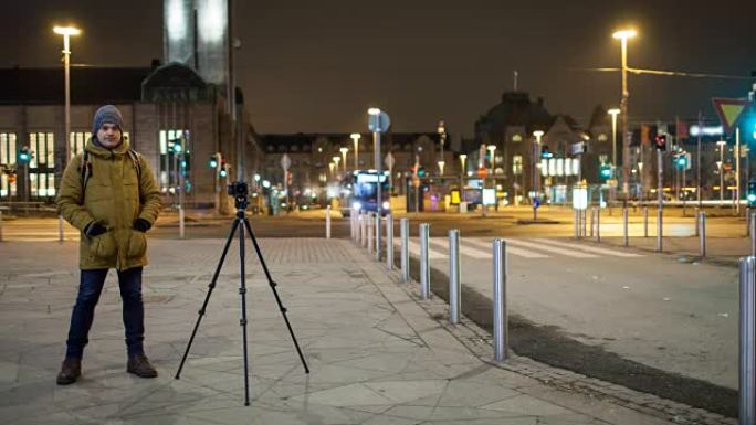 夜间街道的延时与男子拍摄视频。芬兰赫尔辛基