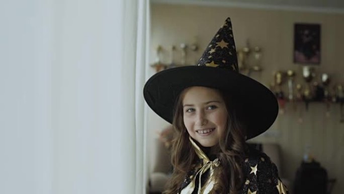 穿着女巫服装的快乐小女孩在镜头前摆姿势