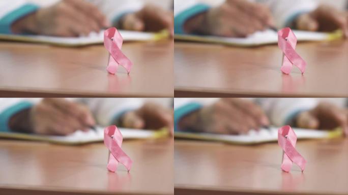 医生桌上的粉红丝带乳腺癌意识符号