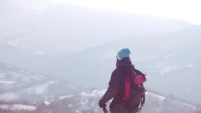 背着背包在山上徒步旅行的人。寒冷的天气，山上下雪。冬季徒步旅行。