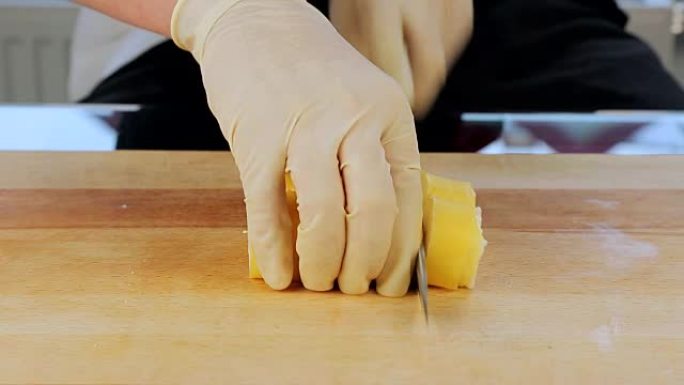 特写。寿司厨师准备面包卷切块。