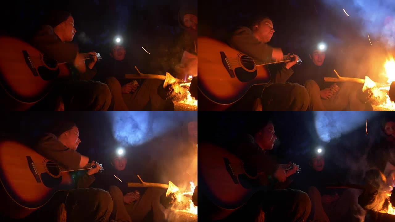 夜木篝火旁年轻朋友唱歌弹吉他