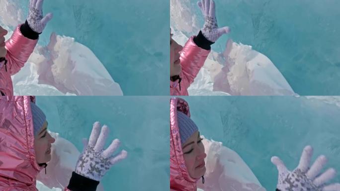 女孩在冰冻的贝加尔湖破裂的冰上行走。女旅行者探索并看着浮冰。这是自然界中最纯净的神奇地方。旅行者整个
