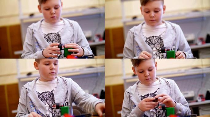 11岁的男孩，从立方体，盘子，电路，电线在设计师中扮演角色。一个小发明家从设计师的不同部分创建机器人