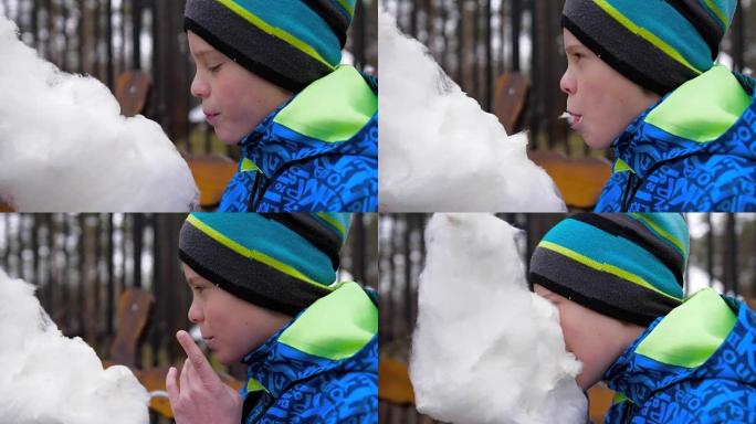 孩子在公园吃棉花糖。甜美通风的甜点
