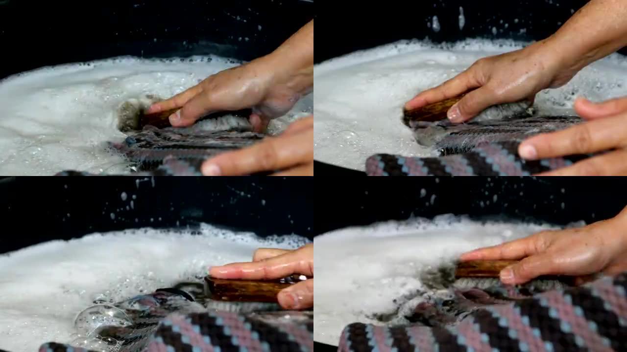 用手在地板上的洗衣板洗脏湿巾。