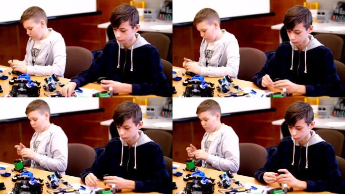 12岁的男孩，从立方体，盘子，电路，电线中扮演设计师。小发明家从设计师的不同部分创造机器人、机器