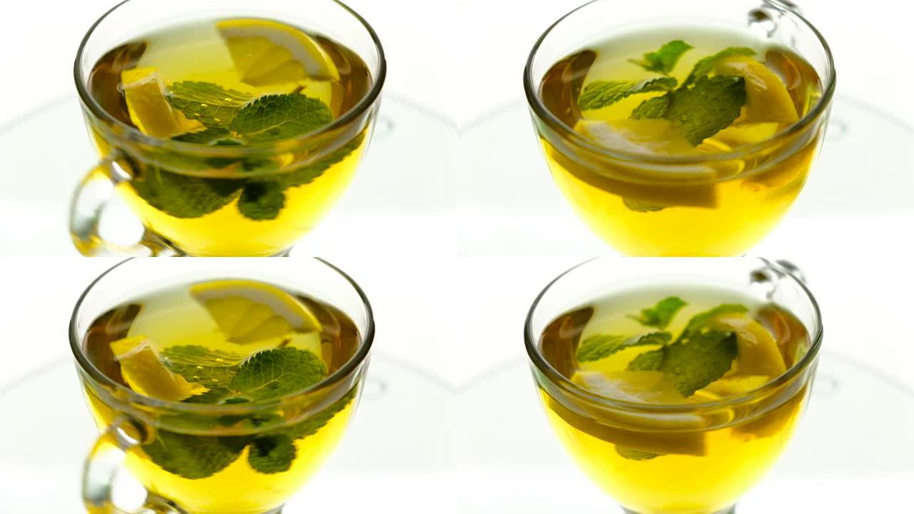 热凉茶配姜、柠檬和薄荷。透明茶壶中的生姜饮料。健康柠檬茶。