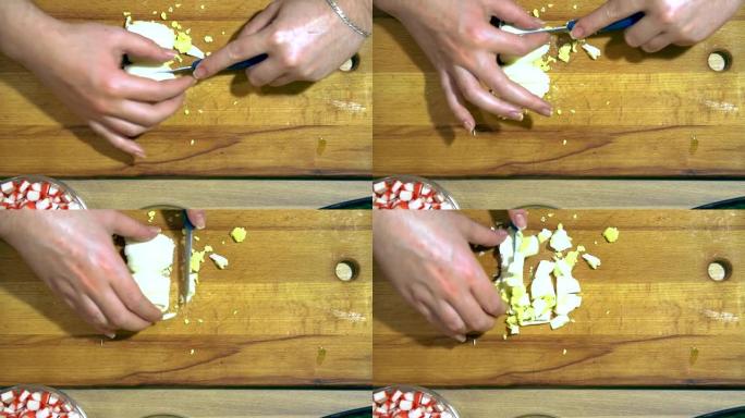 手切鸡蛋的特写。在黄色的厨房板上。