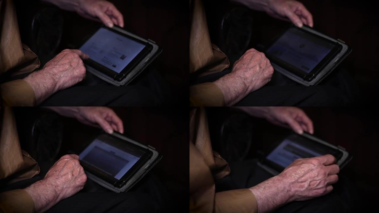 老年人使用平板电脑的手。