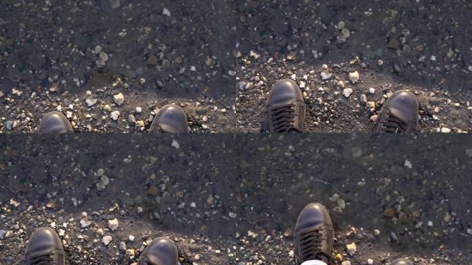 一个穿鞋子的人站在河边或水坑附近，鞋子靠近水