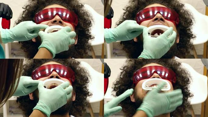 一个人在牙医那里准备牙齿美白的视频，牙医给了他一个护嘴器