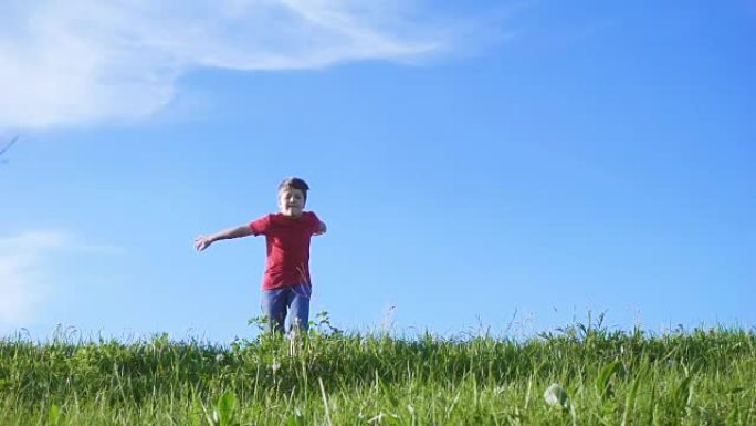快乐男孩在绿草山上跳跃
