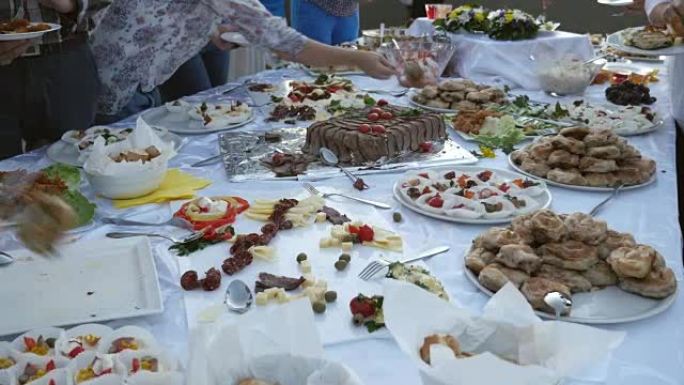 几个人从瑞典餐桌上拿盘子上的食物的镜头
