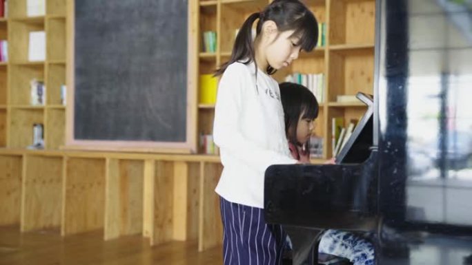 年轻女孩一起弹钢琴