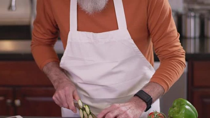 一位老厨师在砧板上切碎黄瓜的平移镜头
