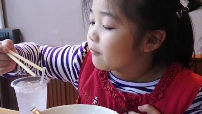 两个亚洲孩子在餐馆吃饭。