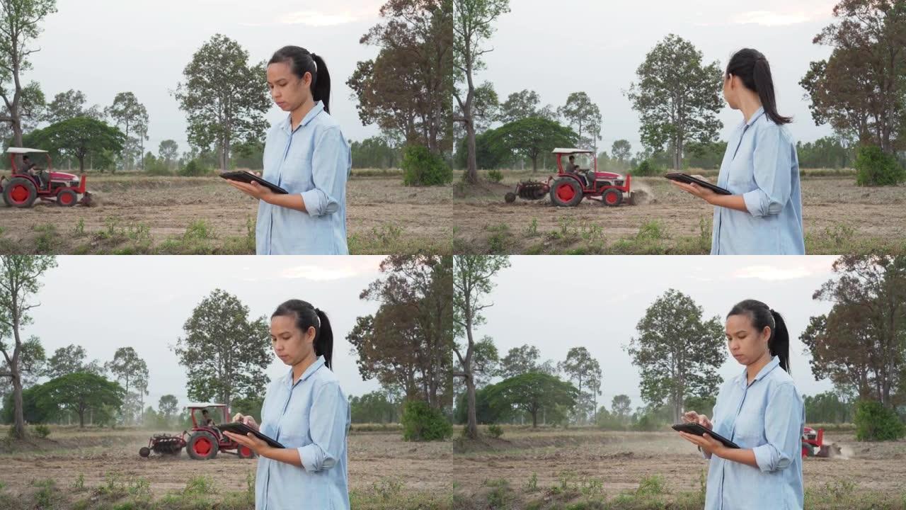 亚洲女性农民在农田使用便携式平板电脑。现代农耕理念，农业先进技术。