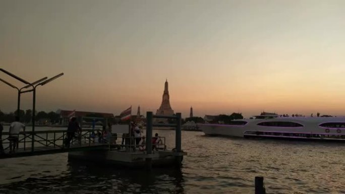 当地人和游客在Chao Praya河通勤。从快速船到泰国曼谷经过的Wat Arun (黎明神庙)。