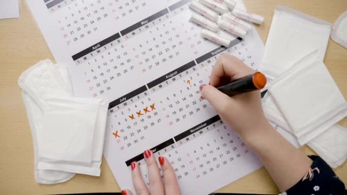 女孩双手计算排卵，并用橙色标记在日历上标记日期，同时询问为什么错过了月经