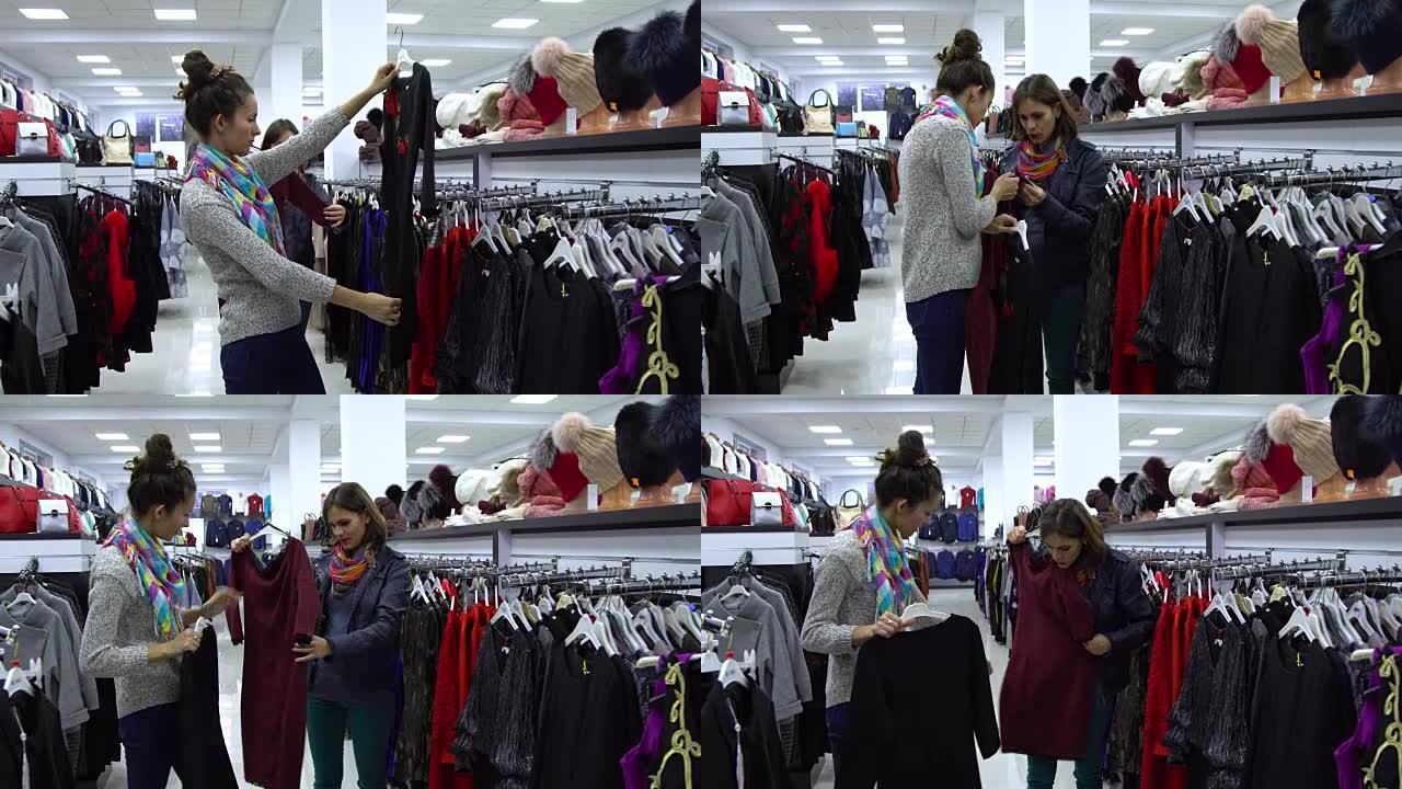 两个年轻漂亮的女孩在时尚的精品店挑选衣服。女孩们仔细看衣服，检查一下。