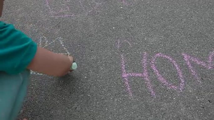 在沥青路面上用彩色粉笔拼写的单词房屋旁边的儿童绘画屋