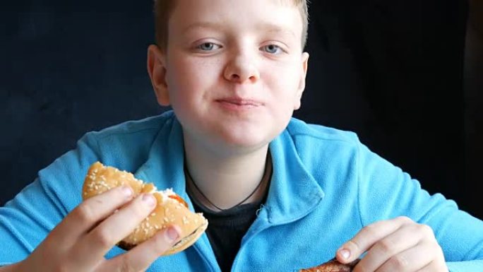 一个蓝眼睛的帅哥少年在快餐店里交替吃汉堡和肥腻的炸鸡翅，看着相机