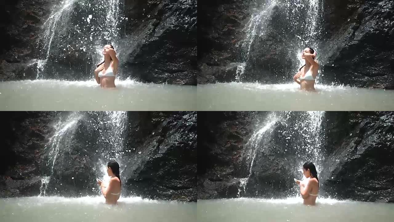 神奇瀑布下的年轻女子在slowmo表达幸福和自由