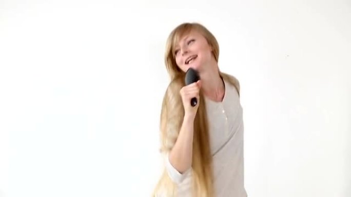 开朗迷人的少女唱着像白色背景上的麦克风一样拿着梳子的歌。