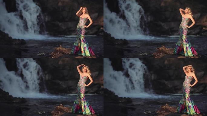 穿着裙子的美丽性感女孩在瀑布背景下摆姿势