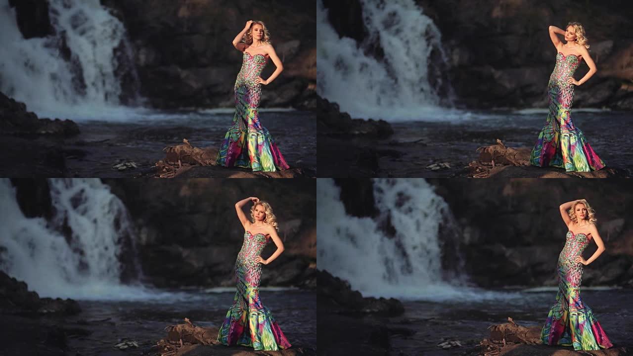 穿着裙子的美丽性感女孩在瀑布背景下摆姿势