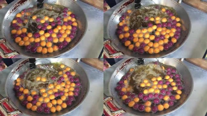 在市场上用热油在大锅中烹饪鹌鹑糖蛋或甲鱼蛋甜食，用木薯粉 (木薯淀粉) 和红薯制成的泰国传统甜点小吃