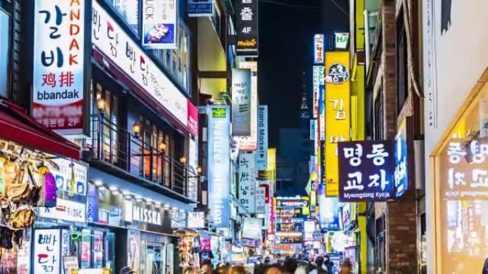 明洞市场的延时。韩国首尔，人们晚上在购物街上散步