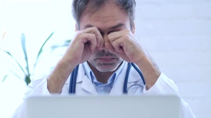 疲惫的医生在诊所工作时揉眼睛，特写