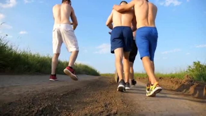男性朋友走在乡间小路上，玩得开心。一群快乐的男孩在户外闲逛。后视图低角度视图特写