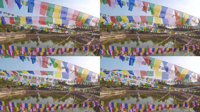 印度马哈菩提寺荷花池塘背景上的彩色旗帜